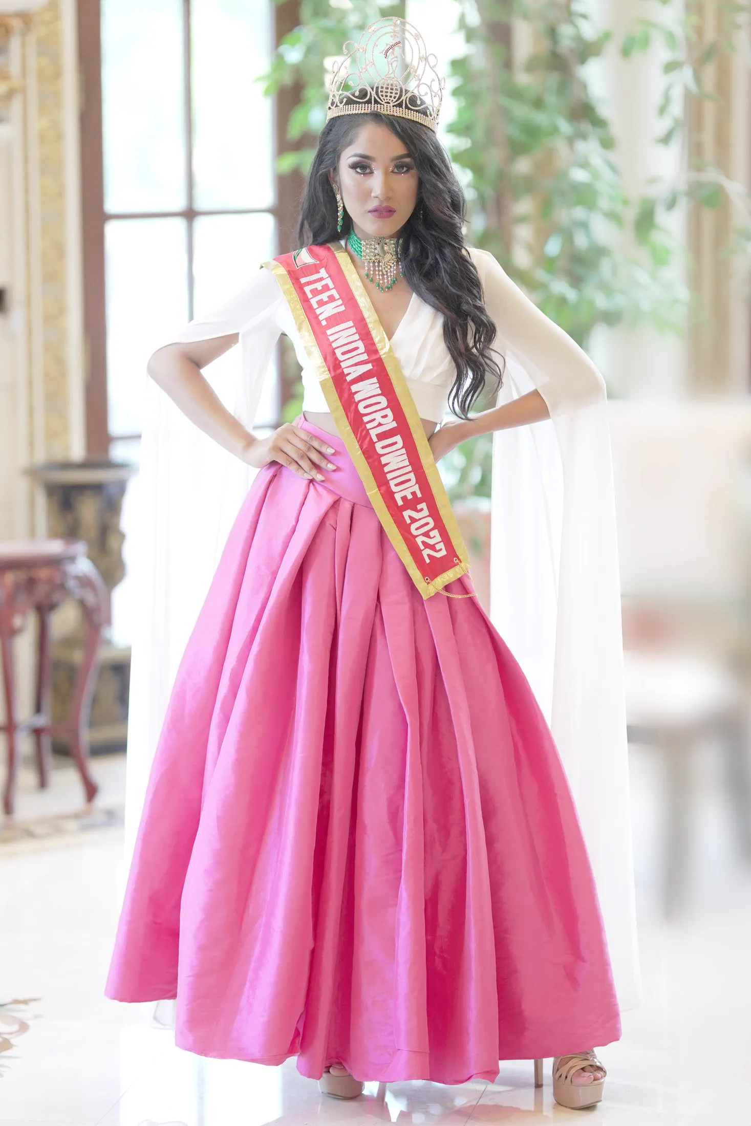A Sweet 16 celebrant in a fuchsia ball gown, tiara, and birthday sash.