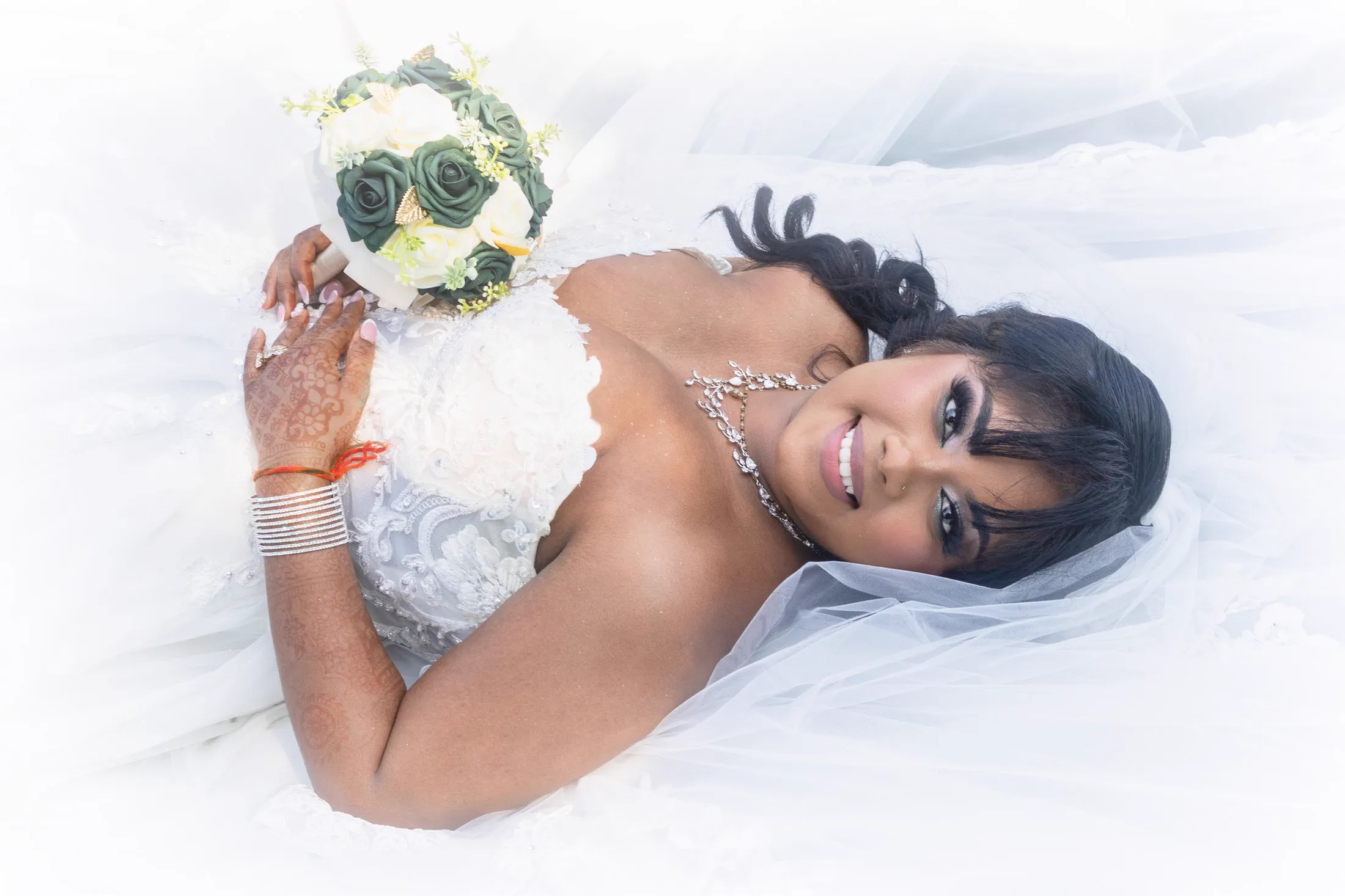 A bride reclines within the sculptural folds of her wedding gown.