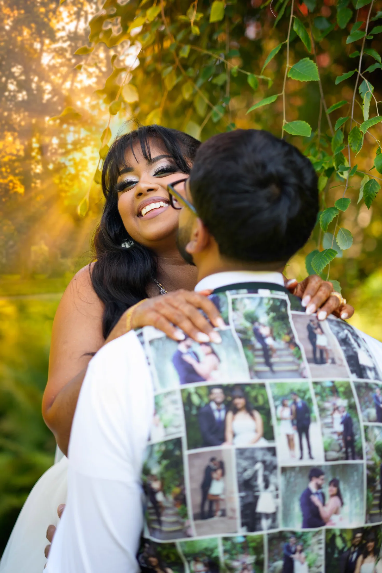 A bride laughs as she holds her groom beneath warm evening light.