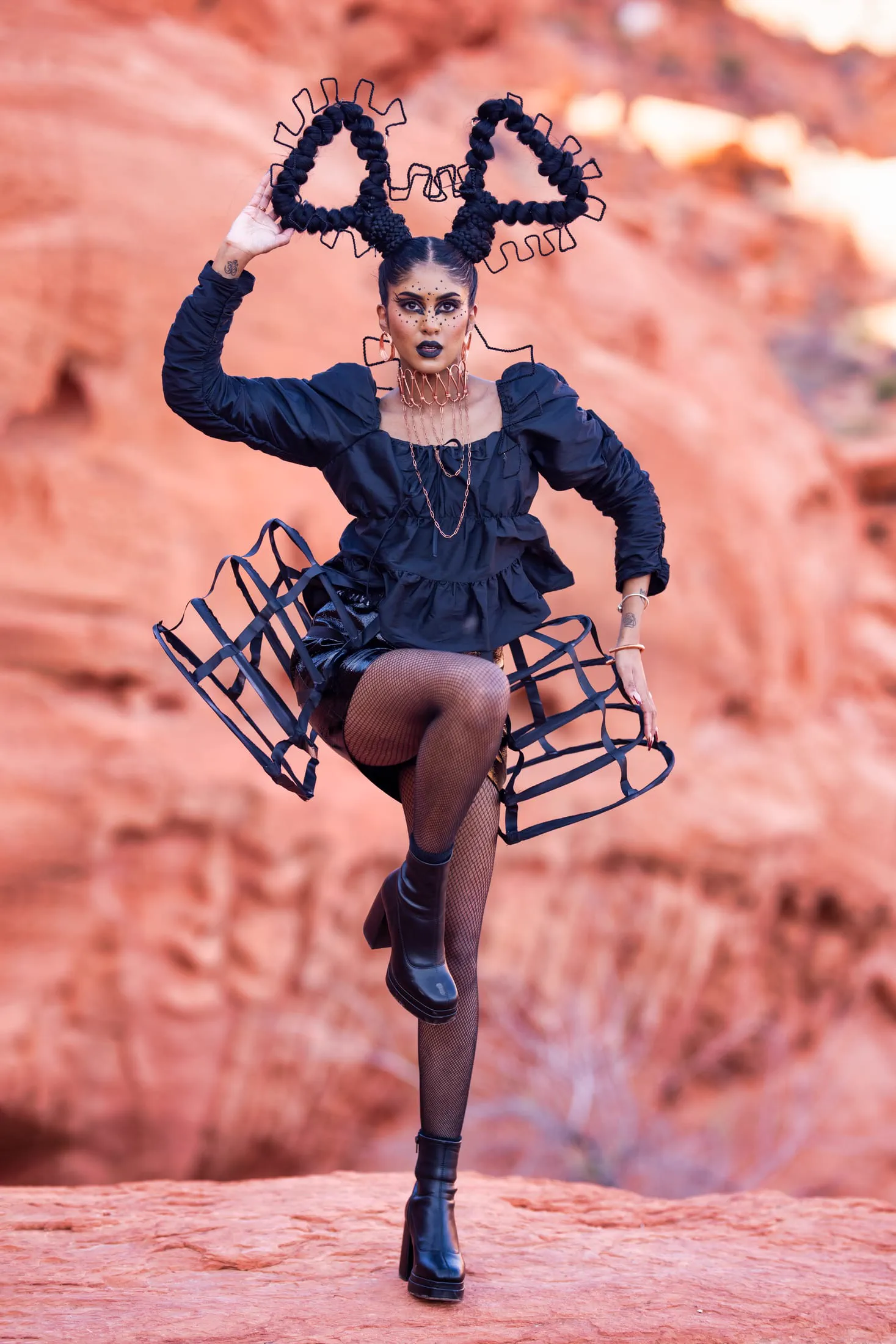 An avant-garde fashion portrait featuring a sculptural cage skirt and braided horn hairstyle.